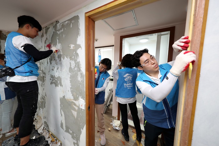 희망의 집 고치기 봉사활동에 나선 대우건설 직원들이 노후된 벽지를 제거하고 있다. 사진=대우건설