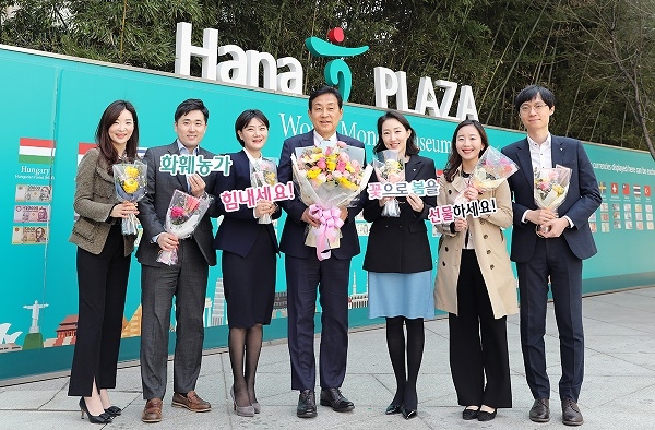 김정태 하나금융그룹 회장(가운데)이 23일 명동 사옥에서 직원들에게 꽃을 선물하고 기념촬영을 하고 있다. 사진=하나금융 제공