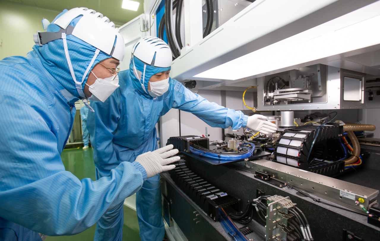 삼성전자 직원(우)과 이오테크닉스 직원(좌)이 양사가 공동 개발한 반도체 레이저 설비를 함께 살펴보고 있다. 사진=삼성전자