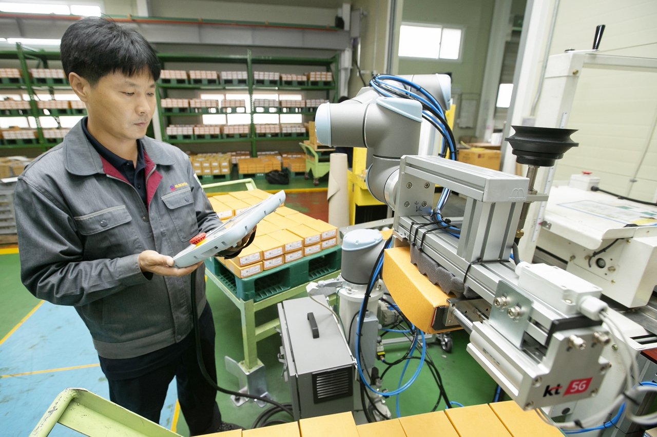충북 제천에 있는 박원 공장에서 생산직 근로자가 KT 5G 스마트팩토리 코봇과 함께 작업하는 모습. 사진=KT