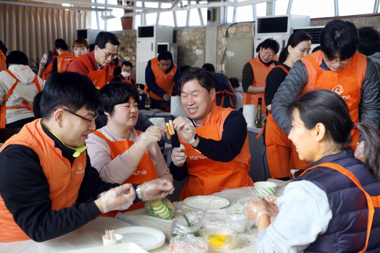 ‘2020 신임 임원 봉사활동’에 참여한 한화그룹 신임 임원들이 발달장애인들과 함께 설 명절 음식을 만들고 있다. 사진=한화