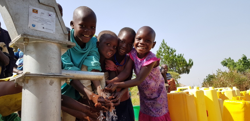 우간다 아루아지역 미테마을. 수리한 식수펌프에 손을 씻으며 즐거워하는 아이들. 사진= 이랜드리테일