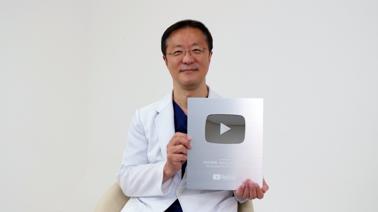 아이디병원 박상훈 병원장이 유튜브 실버 버튼을 들고 기념사진 촬영을 하는 모습. 사진=아이디병원